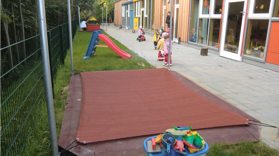 Ein Sonnensegel als Sandkastenabdeckung zum Schutz vor Laub