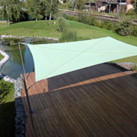 Grünes Sonnensegel über einer Terrasse an einem Teich